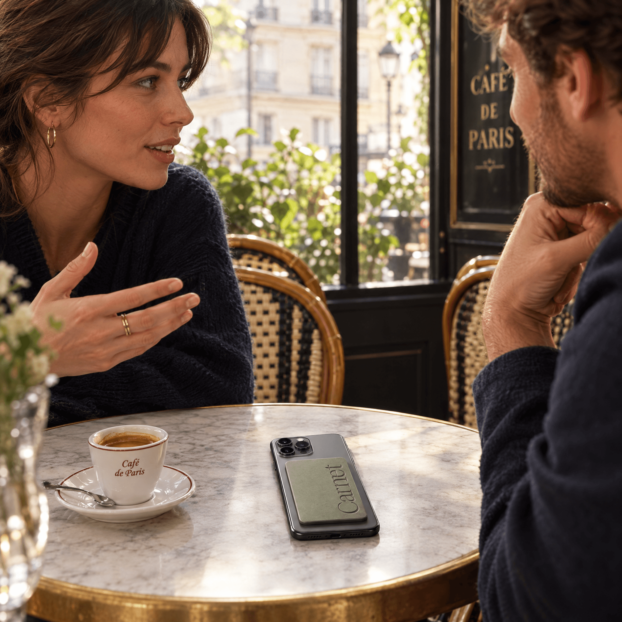 Deux personnes en conversation à une table près d’une fenêtre